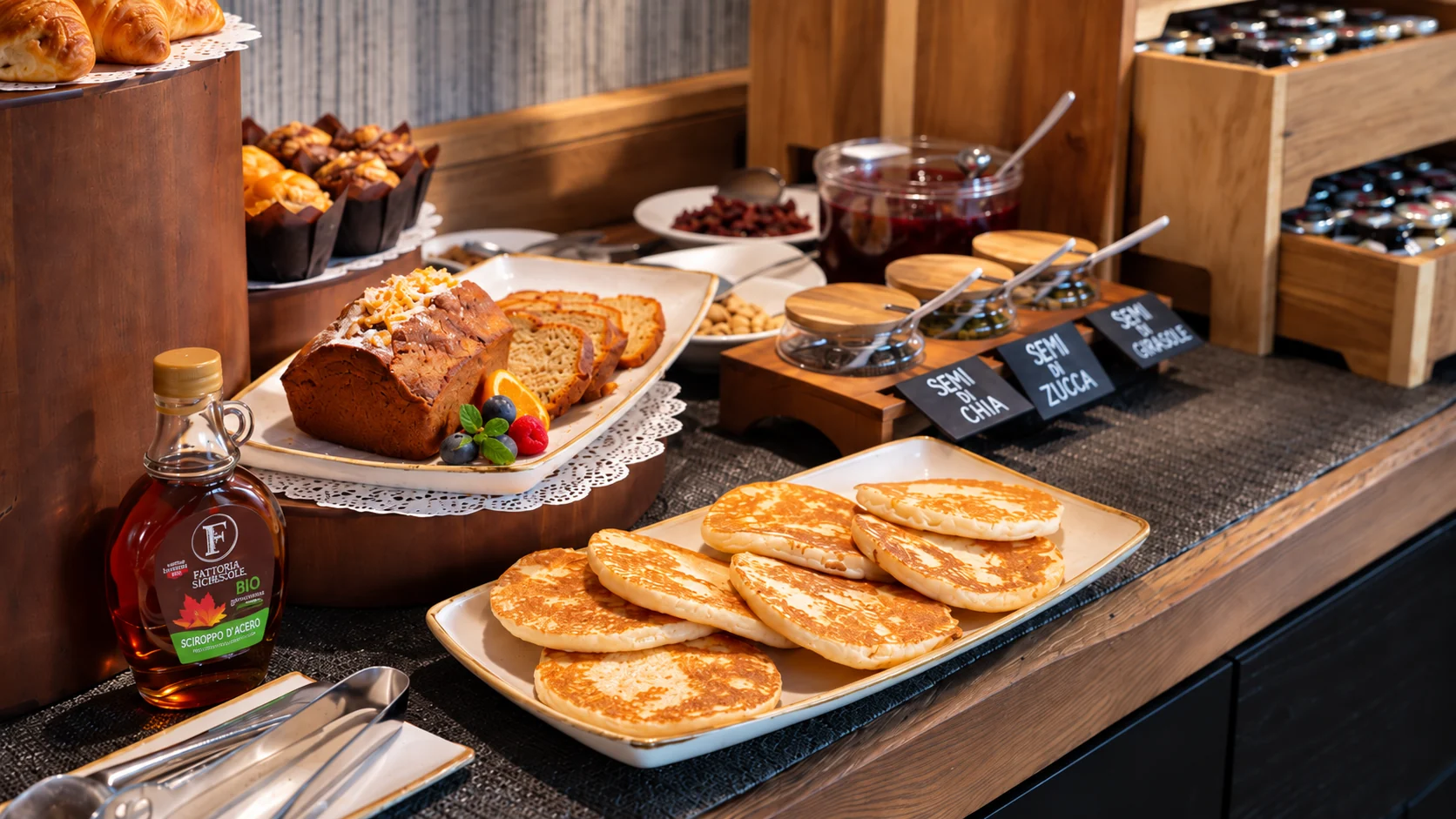 Buffet della colazione con pancake, croissant, dolci e confetture